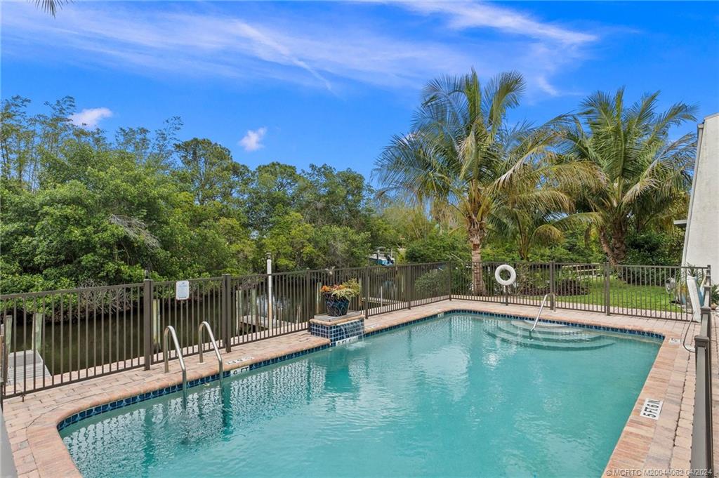 3135 Southeast Indian Street, Unit 5 Stuart, FL 34997 - Photo 37 of 41 a view of a swimming pool with a patio