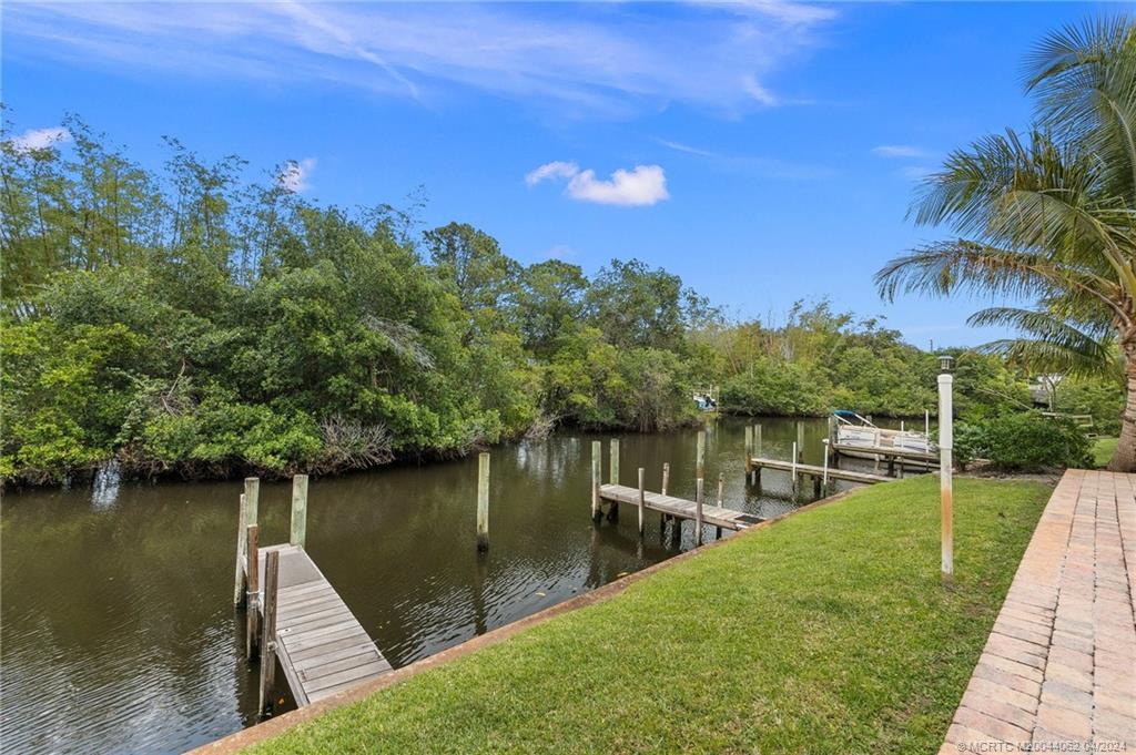 3135 Southeast Indian Street, Unit 5 Stuart, FL 34997 - Photo 38 of 41 a view of a lake with a house in the background