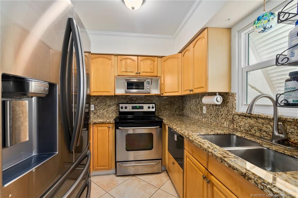 3135 Southeast Indian Street, Unit 5 Stuart, FL 34997 - Photo 9 of 41 a kitchen with a sink stove and refrigerator