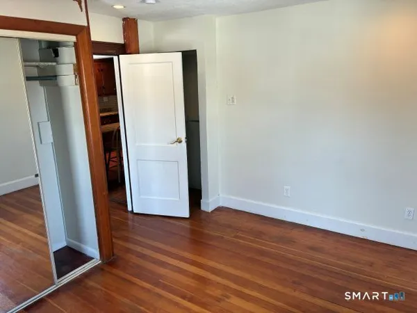 a view of a hallway with wooden floor and staircase