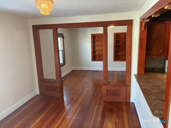 a small space with wooden floor and a window