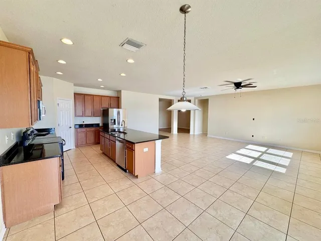 a kitchen with stainless steel appliances kitchen island granite countertop a sink and white cabinets