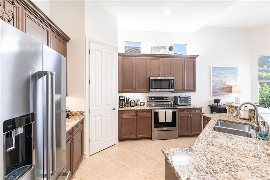 7863 Valencia Court Naples, FL 34113 - Photo 14 of 50 a kitchen with stainless steel appliances granite countertop a refrigerator stove and oven