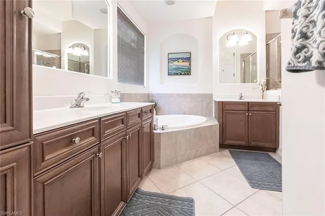 a bathroom with a tub sink and mirror