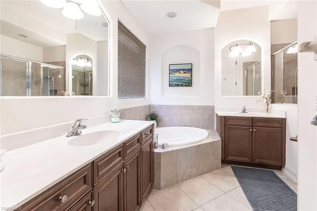 a bathroom with a double vanity sink mirror and bathtub