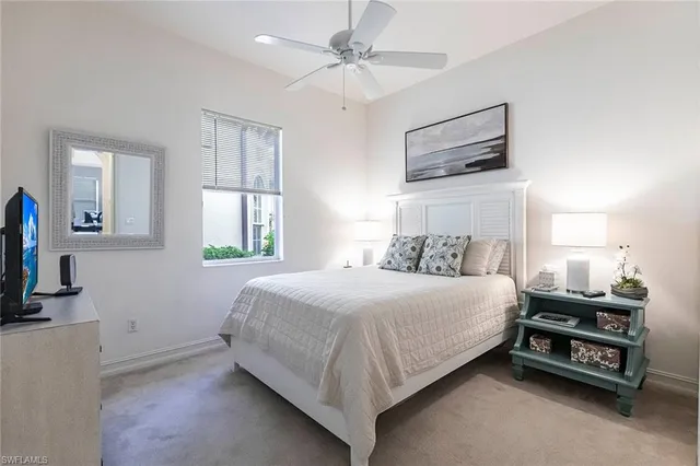 a bedroom with a bed a dresser and flat screen tv
