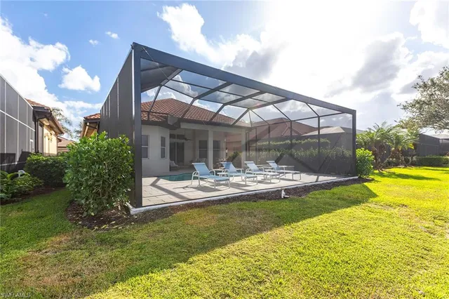 a view of swimming pool with outdoor seating and house in the background