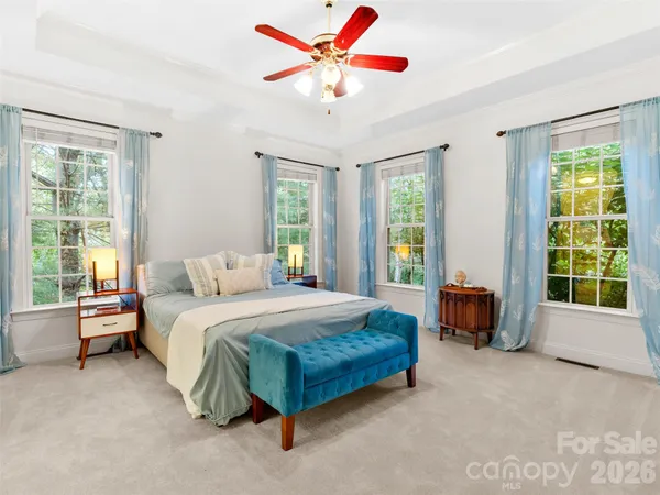 a spacious bedroom with a bed and a large window