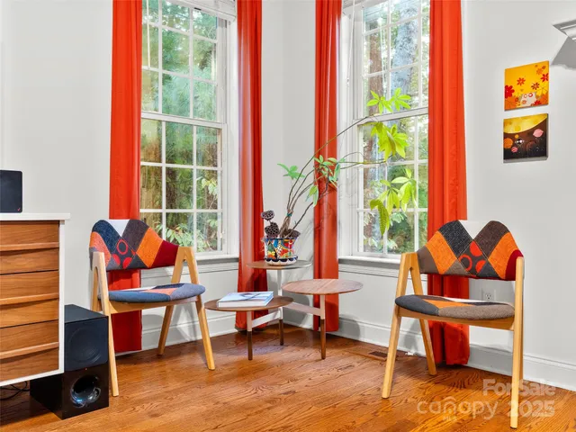 a living room with furniture a rug and a floor to ceiling window
