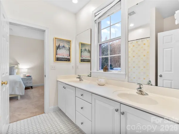 a en suite bathroom with a double vanity sink a mirror and a shower