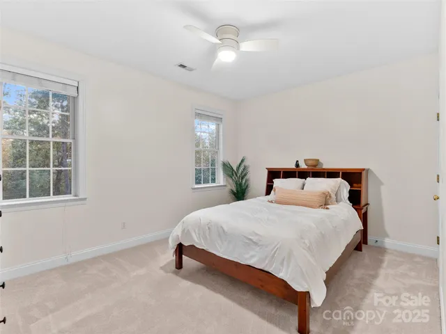 a bedroom with a large bed and a chandelier