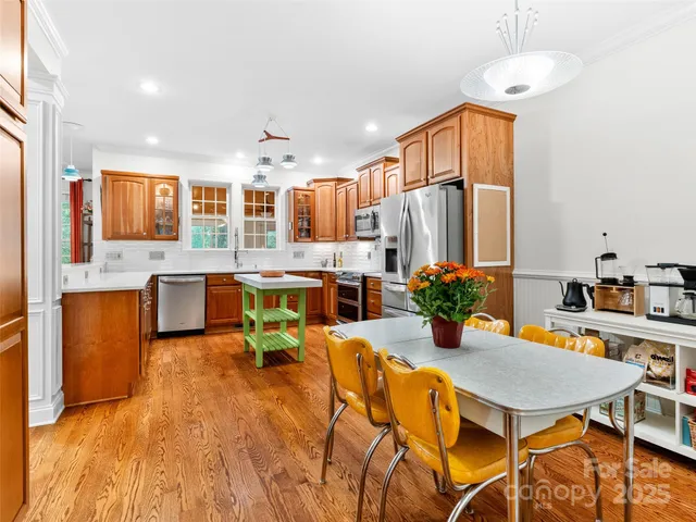 a kitchen with a table chairs sink and refrigerator