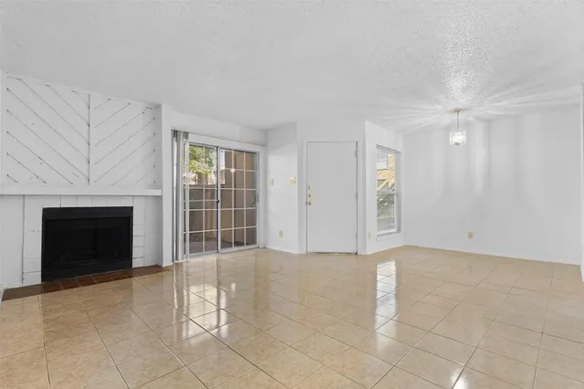 a view of an empty room with a fireplace and a window