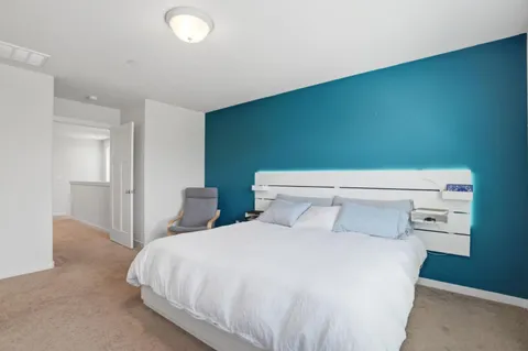 a bedroom with a bed chair and a window