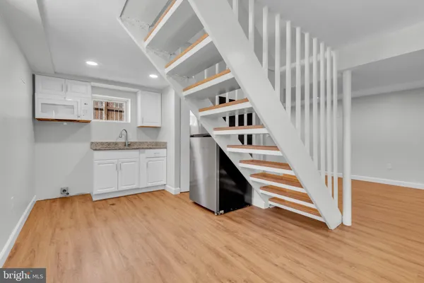 a view of a kitchen with wooden floor and electronic appliances
