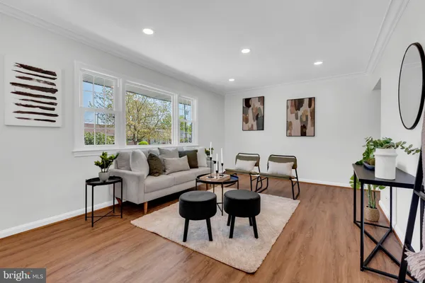 a living room with furniture wooden floor and a window