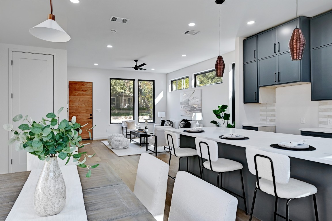 2717 Lyons Road, Unit 1 Austin, TX 78702 - Photo 12 of 35 Kitchen featuring a kitchen bar, decorative light fixtures, recessed lighting, wood finished floors, and tasteful backsplash
