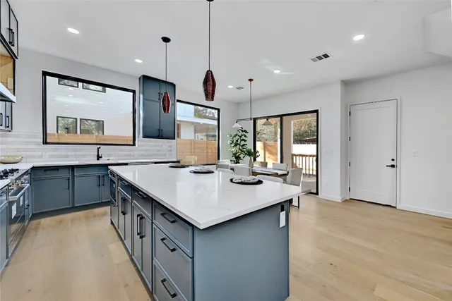 a kitchen with granite countertop a sink stove and cabinets