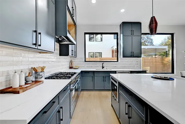 a kitchen with a sink a stove and cabinets