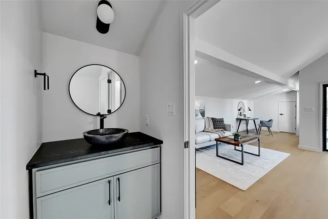 a bathroom with a granite countertop sink and a mirror