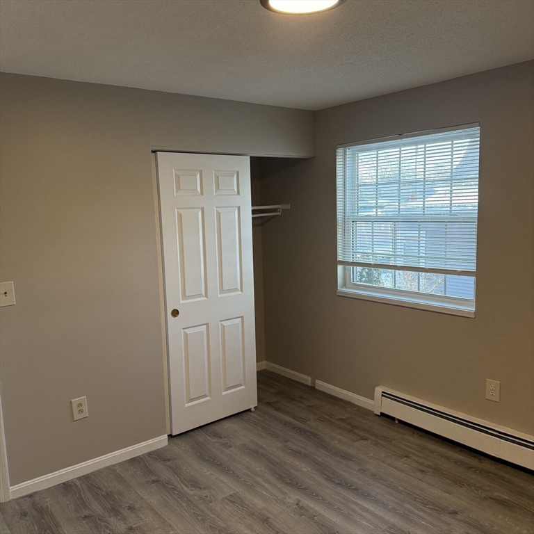 509 Chatham Street, Unit C Lynn, MA 01902 - Photo 6 of 9 an empty room with wooden floor and windows