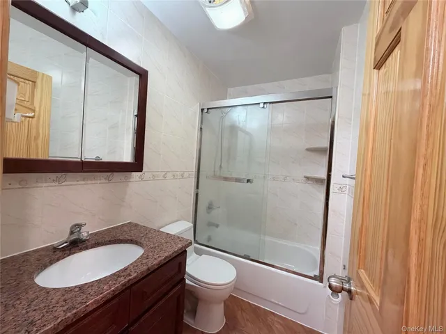 a bathroom with a granite countertop sink toilet a mirror and shower
