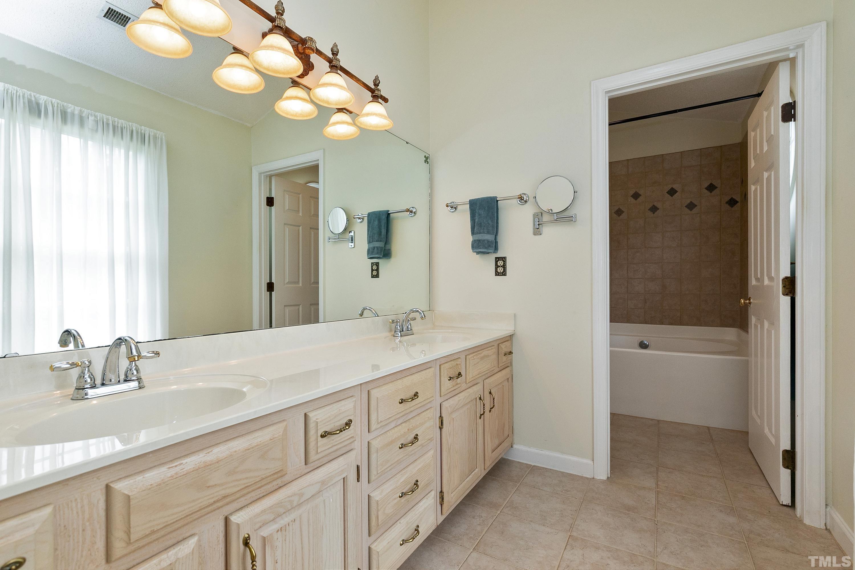 117 Trailing Oak Cary, NC 27513 - Photo 16 of 32 a bathroom with a granite countertop sink mirror and bathtub