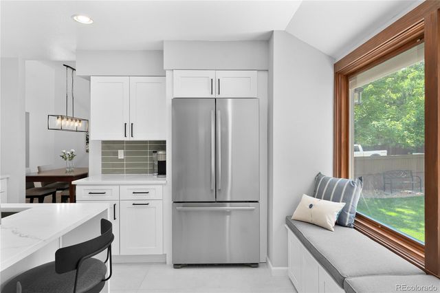 a kitchen with stainless steel appliances a refrigerator and white cabinets