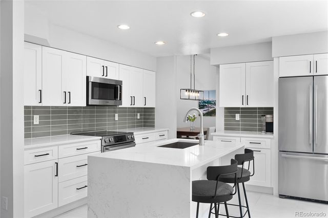 a kitchen with appliances a sink cabinets and a counter top space