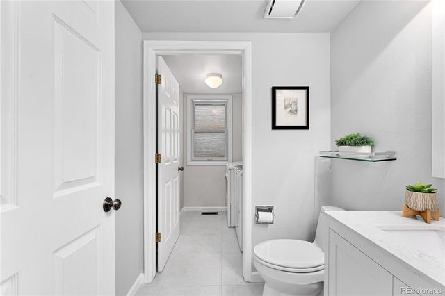 a bathroom with a granite countertop toilet a sink and a mirror