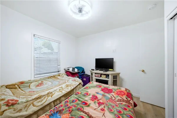 a bedroom with a bed and a flat screen tv on a table