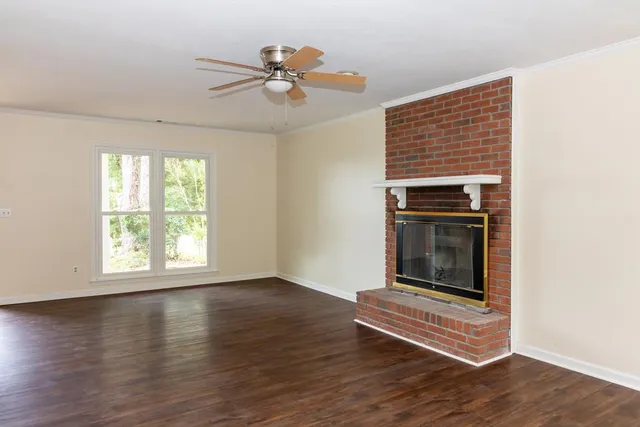 an empty room with a ceiling fan and carpet