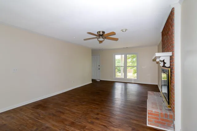 an empty room with a window and a fan