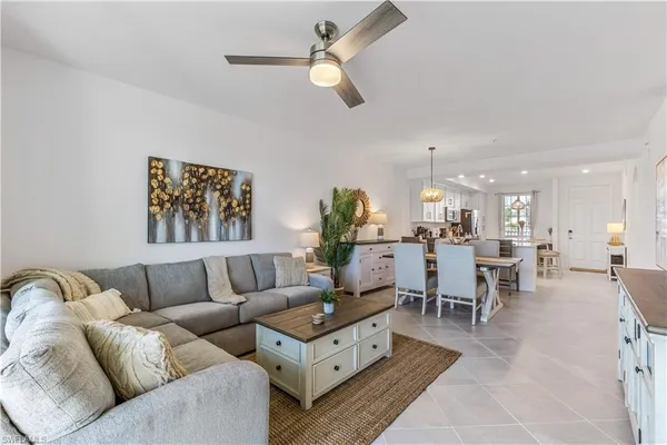 a living room with furniture kitchen view and a chandelier