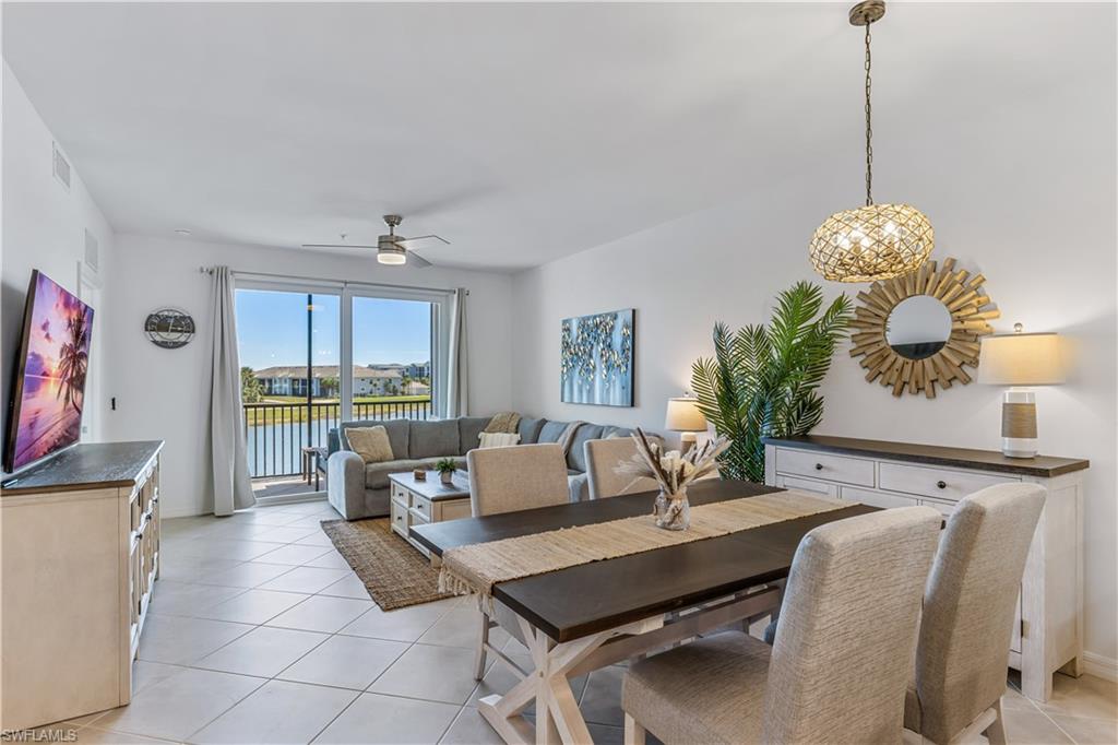 43989 Boardwalk Loop, Unit 2025 Babcock Ranch, FL 33982 - Photo 4 of 14 a living room with furniture a dining table and a chandelier