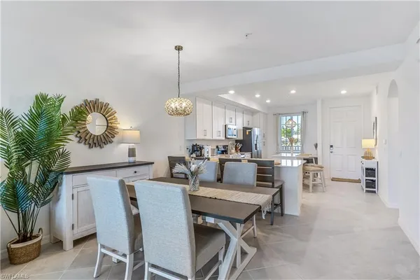 a view of a dining room and livingroom with furniture wooden floor a rug and a chandelier