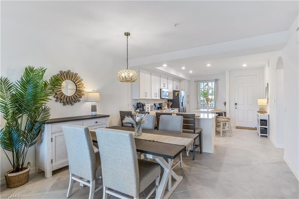 43989 Boardwalk Loop, Unit 2025 Babcock Ranch, FL 33982 - Photo 7 of 14 a view of a dining room and livingroom with furniture wooden floor a rug and a chandelier