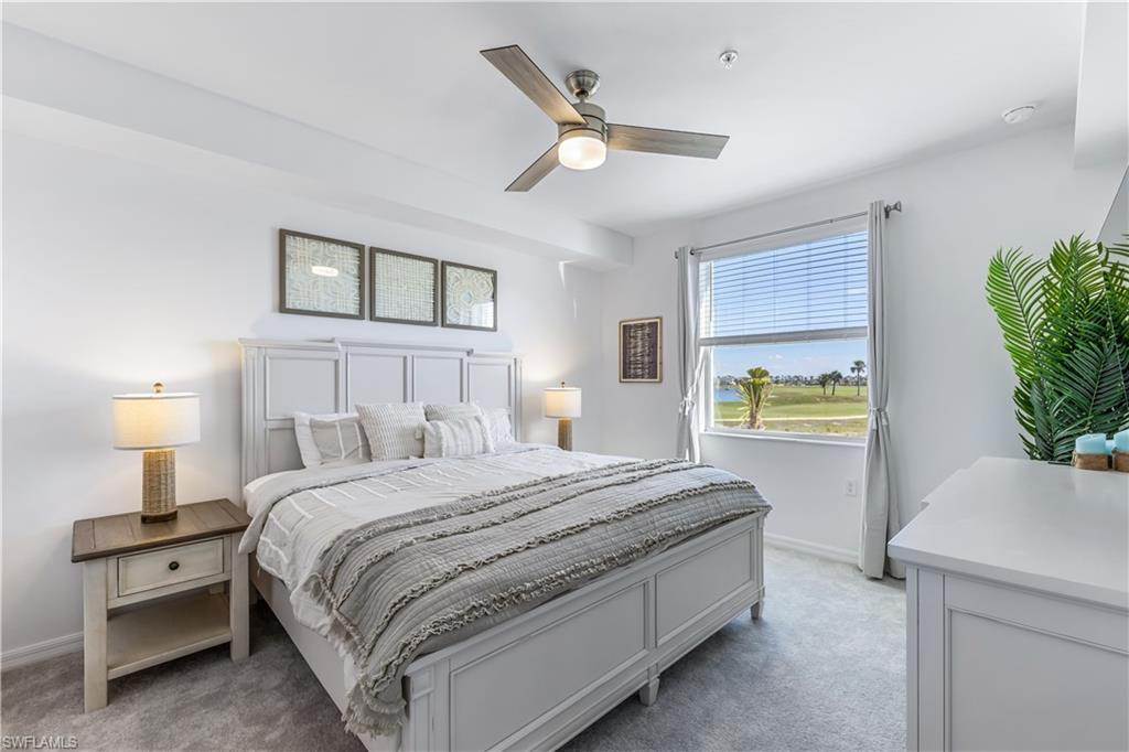 43989 Boardwalk Loop, Unit 2025 Babcock Ranch, FL 33982 - Photo 10 of 14 a bedroom with a bed a dresser and a chandelier