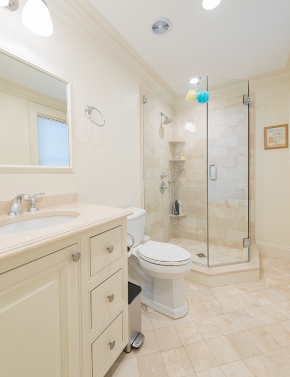 139 Arnold Road Newton, MA 02459 - Photo 15 of 30 a bathroom with a toilet a sink a glass door a shower a mirror and vanity
