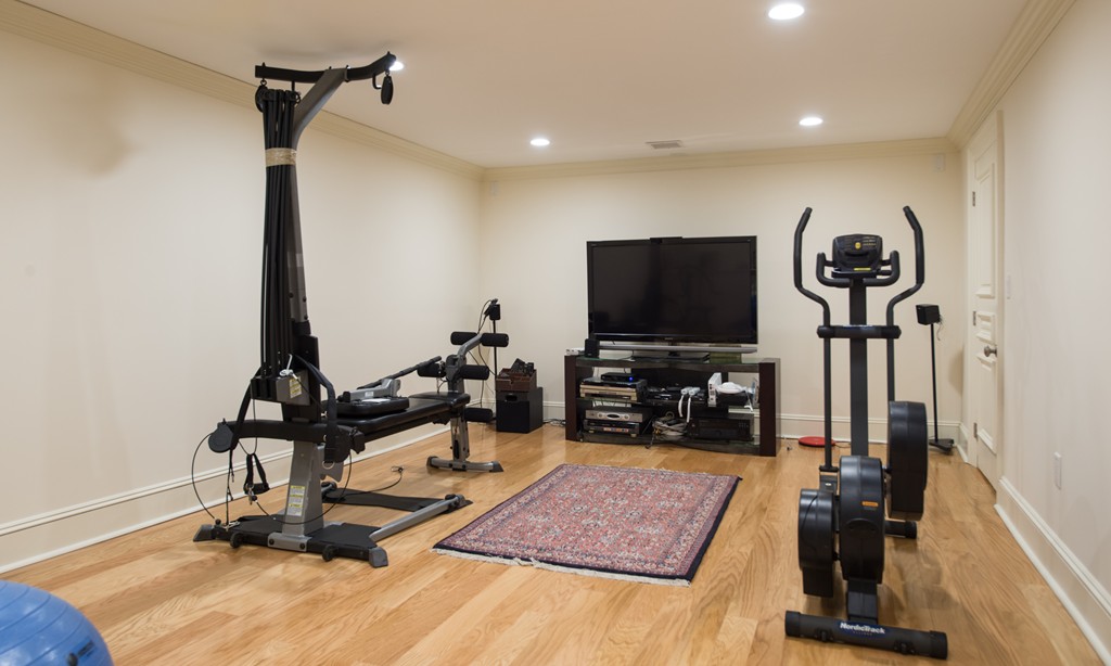 139 Arnold Road Newton, MA 02459 - Photo 22 of 30 a room with gym equipment and a flat screen tv
