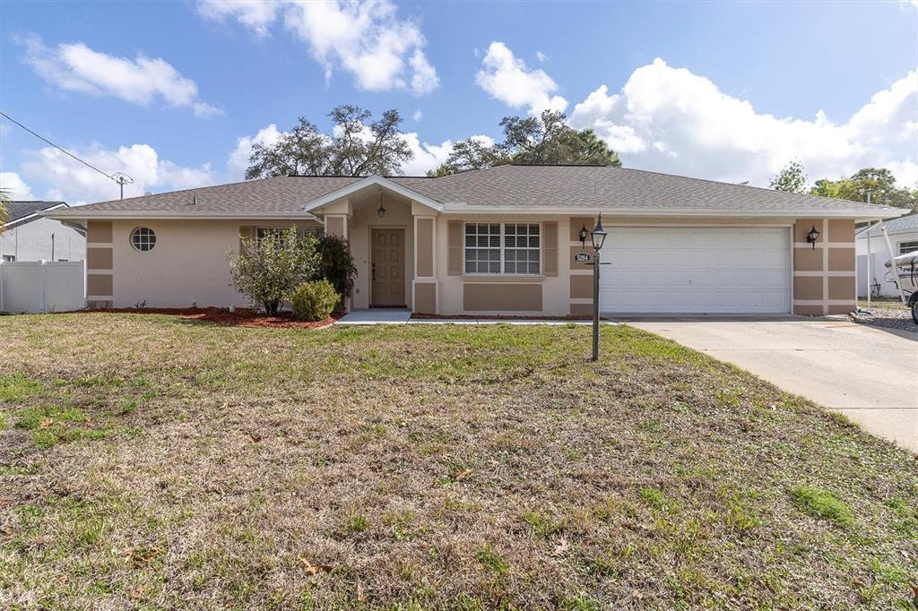 a view of a house with a yard and garage