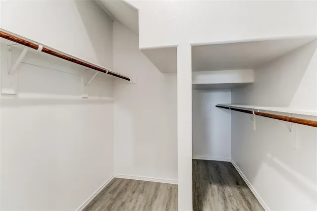 a view of walk in closet with wooden floor