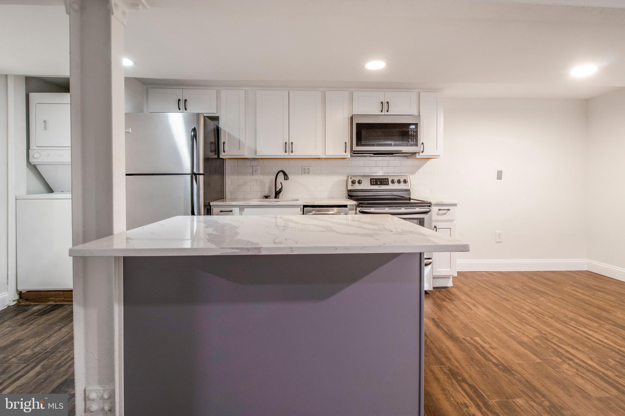 104 15th Street Southeast, Unit B Washington, DC 20003 - Photo 11 of 18 a kitchen with kitchen island a sink stainless steel appliances and cabinets