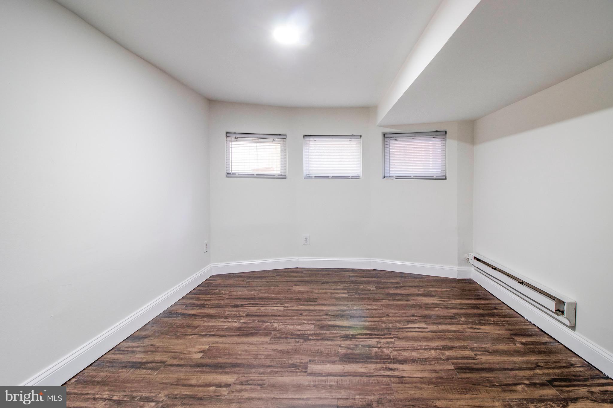 104 15th Street Southeast, Unit B Washington, DC 20003 - Photo 14 of 18 a view of an empty room with wooden floor and a window