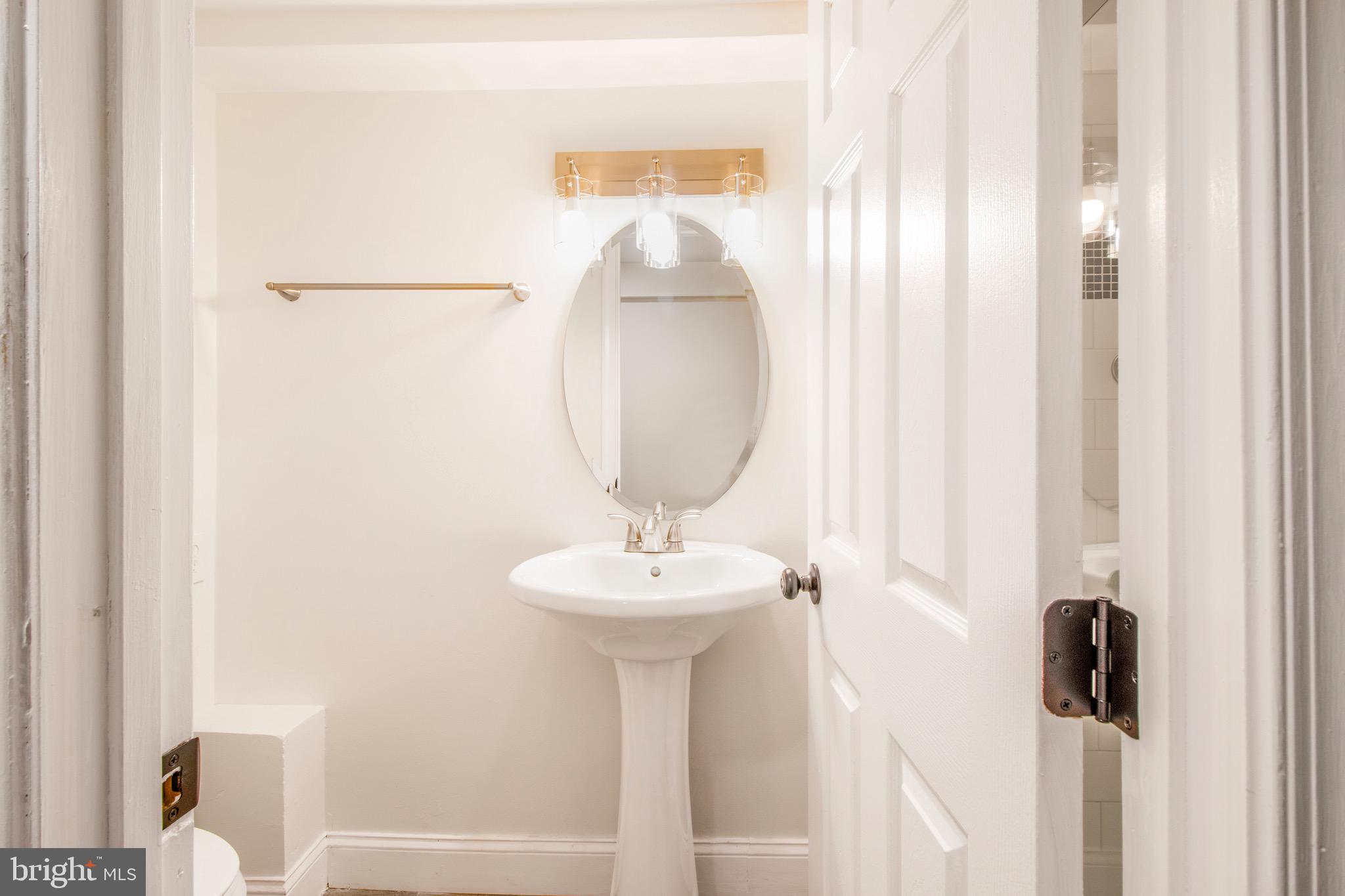 104 15th Street Southeast, Unit B Washington, DC 20003 - Photo 16 of 18 a bathroom with a sink a mirror and a window