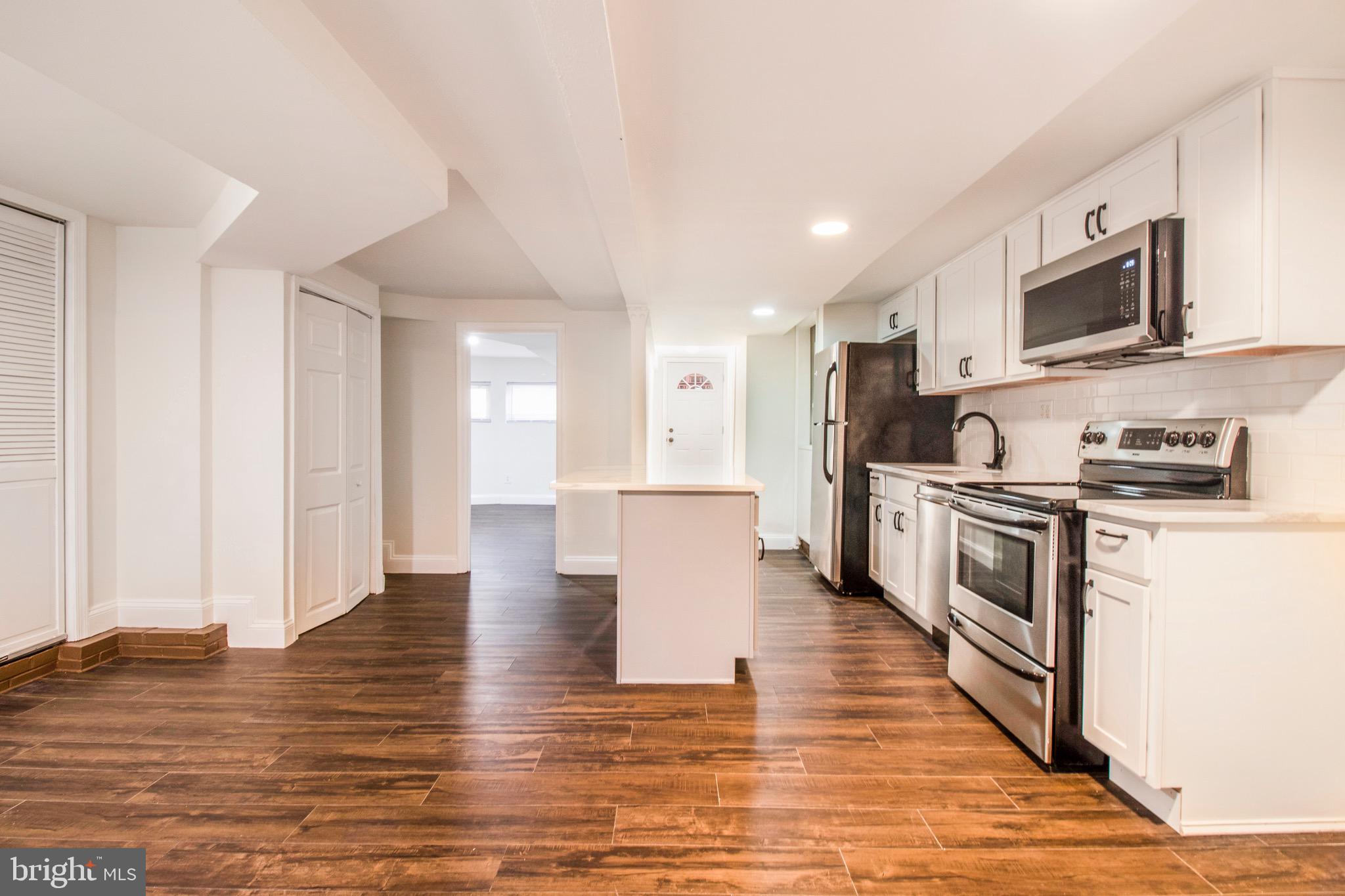 104 15th Street Southeast, Unit B Washington, DC 20003 - Photo 2 of 18 a kitchen with stainless steel appliances granite countertop a stove top oven a sink dishwasher and white cabinets with wooden floor