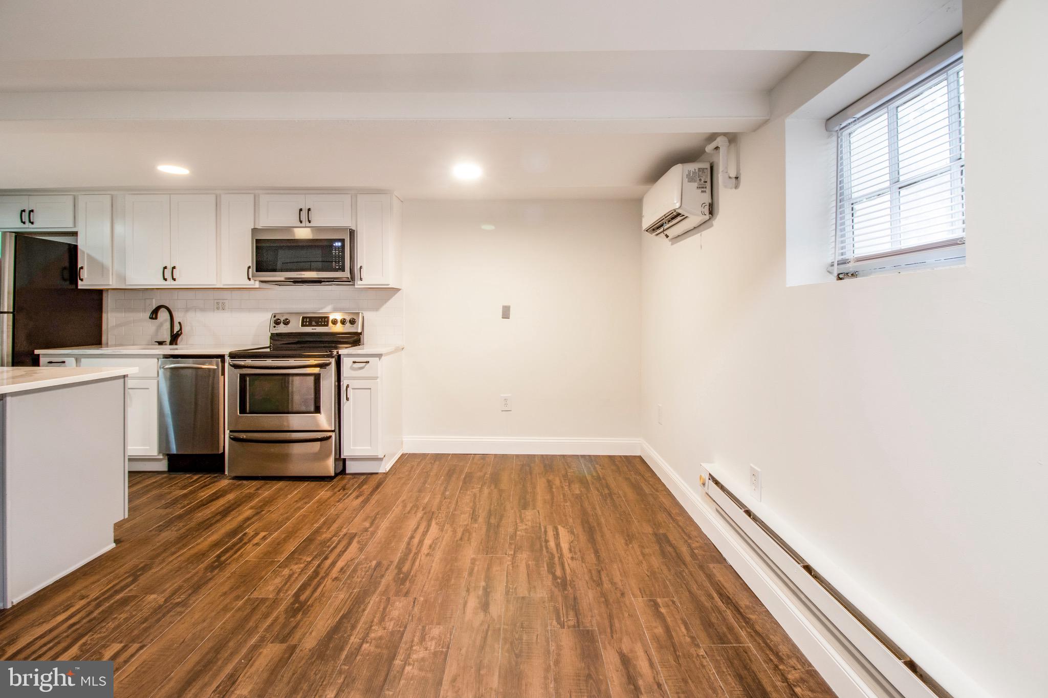 104 15th Street Southeast, Unit B Washington, DC 20003 - Photo 4 of 18 a kitchen with stainless steel appliances a stove top oven a sink dishwasher and a microwave with wooden floor