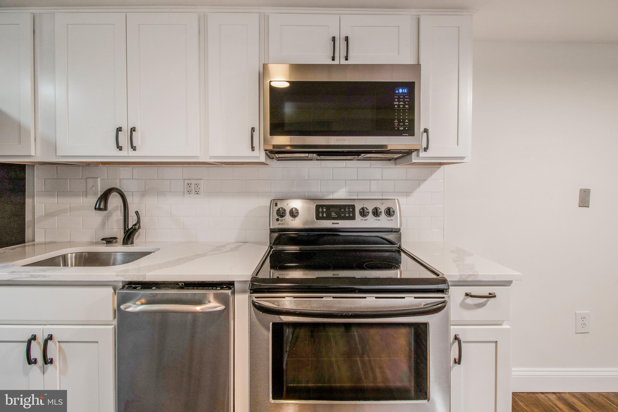 104 15th Street Southeast, Unit B Washington, DC 20003 - Photo 6 of 18 a kitchen with a stove and a microwave
