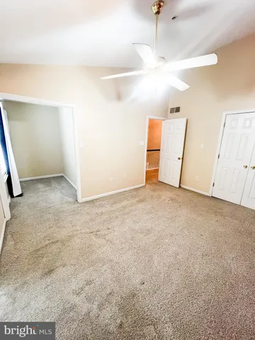 an empty room with closet and windows