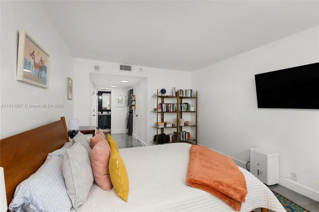 a bed room with a bed a television and a lamp